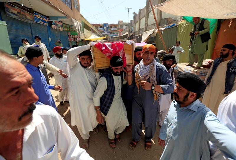 Afghan Sikh men carry the coffin of a bombing victim in Jalalabad, Afghanistan, July 2, 2018.